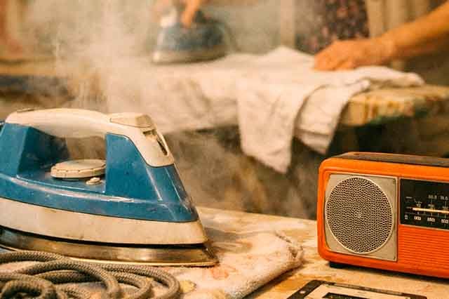 Cocina de los años 80 con plancha azul, transistor naranja y vapor subiendo, evocando la intimidad y melancolía de Love of the Common People de Paul Young